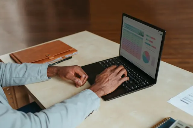 Laptop screen, office setting, somebody working.