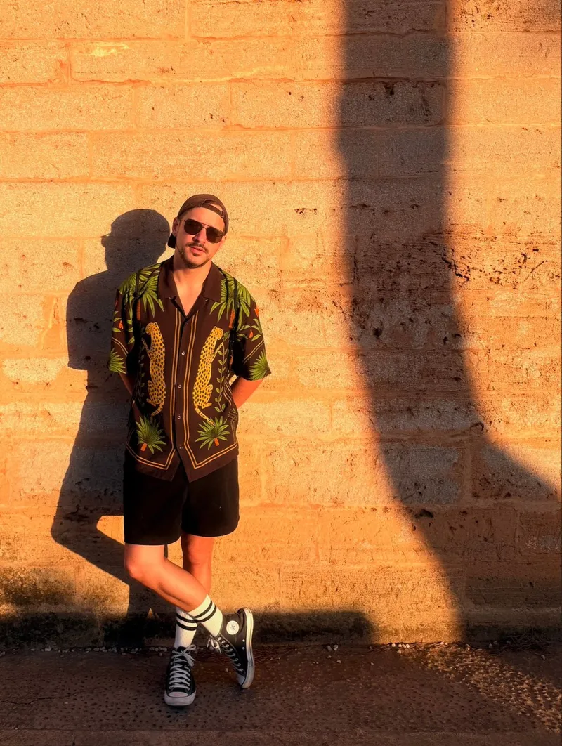 Peter Balog, founder of ContentPeter, standing against a sunlit stone wall